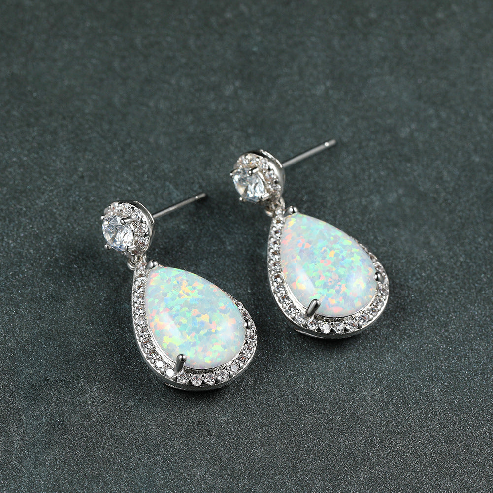 "Elevate your style with these Platinum Opal Water Drop Earrings. The elegant water drop design adds a touch of wildness and the opal centerpiece exudes a sophisticated charm. Perfect for any occasion, these earrings will make you stand out and feel confident"